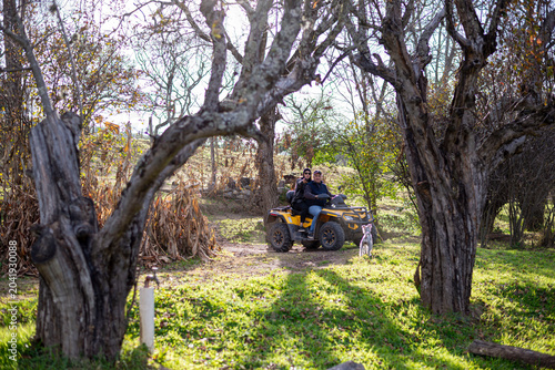 Foto People riding a quad bike with dog through rural nature