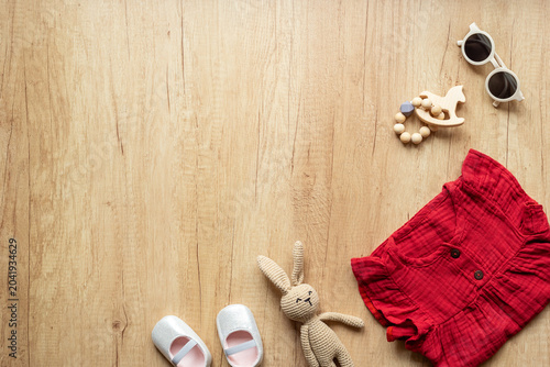 Tableau sur toile Baby girl red cotton muslin dress with shoes and knitted bunny toy, top view