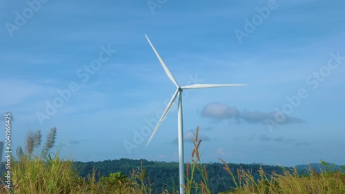 Aerial view of powerful Wind turbine farm for energy production on beautiful cloudy sky at highland. Wind power turbines generating clean renewable energy for sustainable development green energy. 