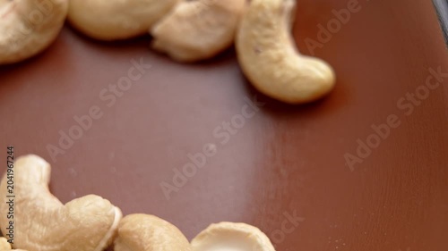 Stainless steel spoon scooping dried cashew nuts. Health food ingredient close up