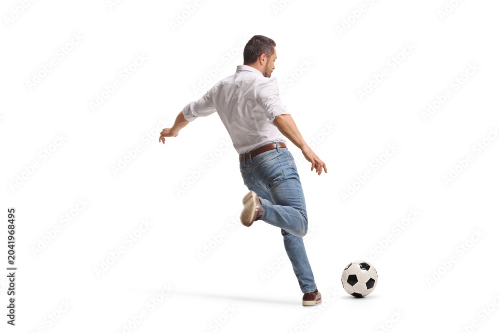 Naklejka premium Man in casual clothes kicking a football