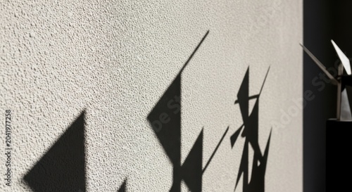 Rough stucco wall with fine grain texture and sharp angular shadows, abstract architectural background