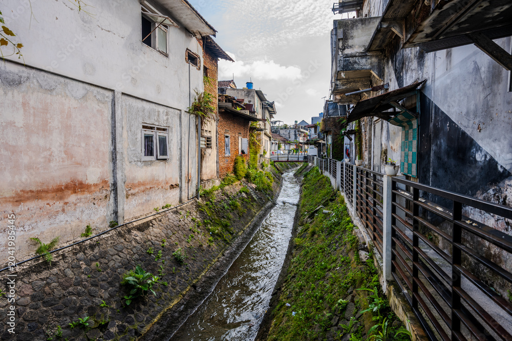 Fototapeta premium Narrow canal between residential buildings in Kota Malang