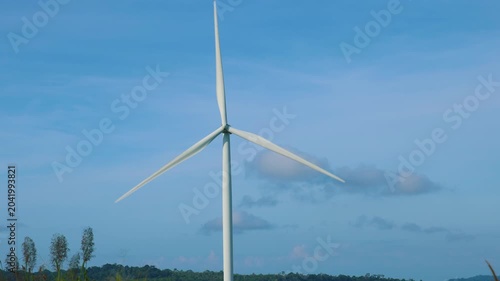 Aerial view of powerful Wind turbine farm for energy production on beautiful cloudy sky at highland. Wind power turbines generating clean renewable energy for sustainable development green energy. 