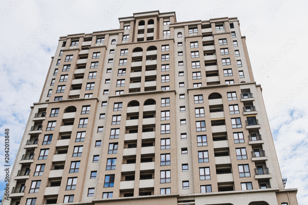 Fototapeta premium Symmetrical residential facade with repetitive arches and aligned balconies, highlighting proportion, rhythm and classicalinspired modern design for architectural use