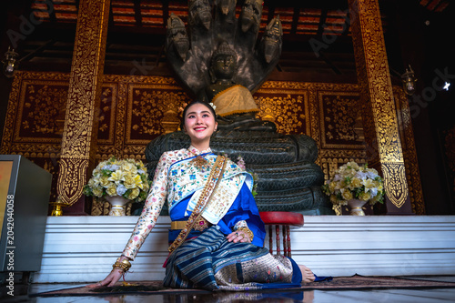 Bild auf Leinwand Elegant Asian woman in beautiful Thai traditional dress sitting respectfully ins