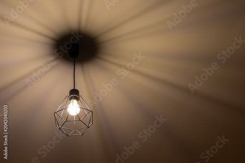 Fotografie Modern Geometric Pendant Light Casting Shadows on Ceiling