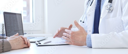 Adult doctor gesturing with hands while explaining diagnosis to patient during medical consultation in hospital office, healthcare and medical concept. Medicine concept