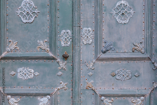 Photos Close up of an antique ornate metal door with baroque decorations and verdigris patina, historic church gate detail of Furstenfeld Abbey in Furstenfeldbruck, Bavaria, Germany