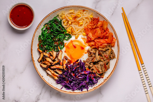 Bibimbap with colorful vegetables, beef, and egg