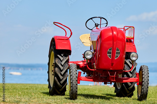 Klassischer roter Oldtimer-Traktor auf der Wiese