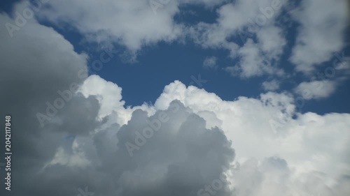 Puffy clouds moving across blue sky timelapse