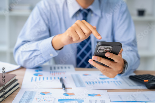 Business professional analyzing data on smartphone office environment digital report focused viewpoint modern concept