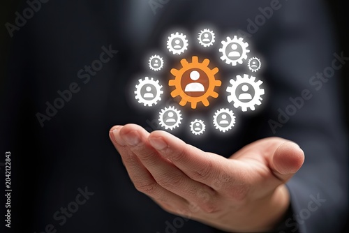A hand holds a glowing network of interconnected people icons forming a gear