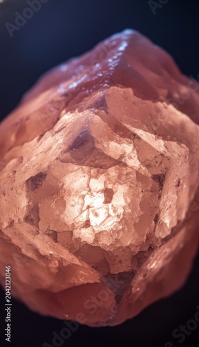Close-up of a Glowing Pink Himalayan Salt Crystal on Dark Background