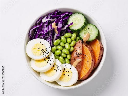 Clean eating protein bowl with fresh vegetables and sweet potato on white background