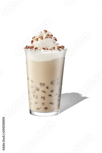 Eye level shot of boba bubble milk tea drink with whipped cream and tapioca pearls, isolated.