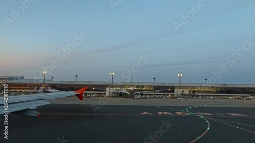 2026年4月、成田国際空港にて、タキシング中の機内窓から見える誘導路と空港ターミナルビルの景色