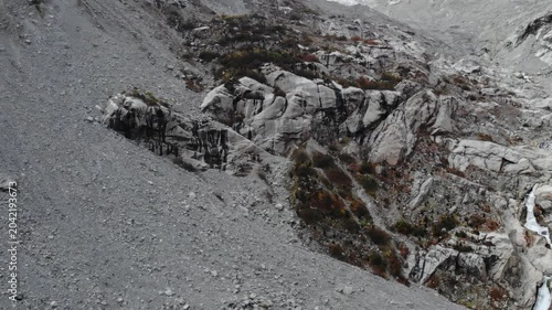 Rugged rocky mountain slope with scree and snow in cold daylight . Media