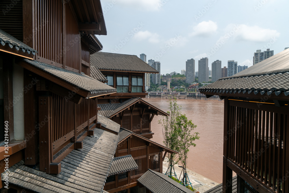 Fototapeta premium Traditional riverside architecture overlooking muddy urban river