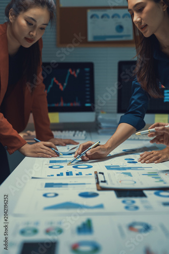 Business team collaborating on data analysis, reviewing financial reports and marketing statistics in a modern office meeting