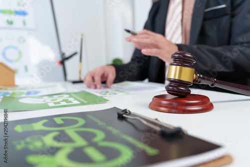 Person working on Environmental, Social, and Governance - ESG - strategy and regulations with a gavel on the table, indicating legal compliance