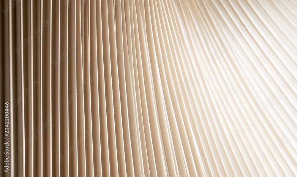 Fototapeta premium Pleated texture, light and shadow play across neutral-toned, parallel lines