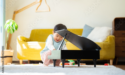 Foto リビングでおもちゃのピアノを弾く3歳の男の子