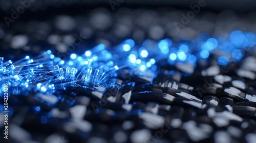 Extreme close-up of woven carbon fiber with blue fiber optic strands