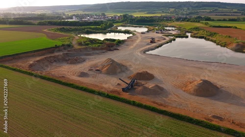 Drone footage over a gravel pit and processing facility in Baden-Wuerttemberg, Germany, capturing quarry operations, stockpile management and resource extraction activities