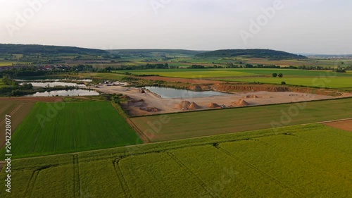 Aerial drone view of a gravel quarry in Baden-Wuerttemberg, Germany, showing aggregate stockpiles, sand extraction areas and industrial processing facilities supplying raw materials for construction