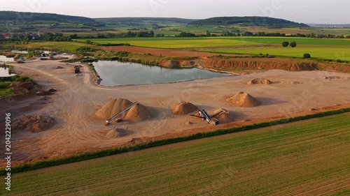 Elevated drone perspective of a gravel factory and quarry site showing material processing, earthmoving activities and aggregate resources for concrete production