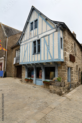 Obraz na plátně Typical architectural style of a side street with houses and shops in Guerande,