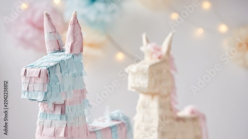 Colorful unicorn pinatas adorned with pastel fringes for a festive celebration.