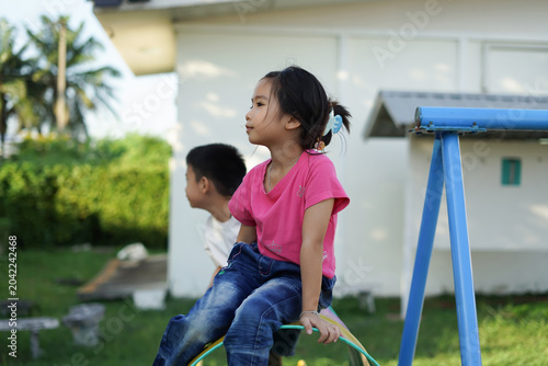 Фотография Little girl rides swing with joyful expression