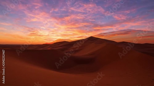 Golden desert dunes at sunset with clear blue sky