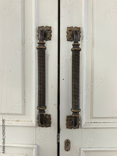 Foto Antique brass door handles on white wooden doors of a historic manor house
