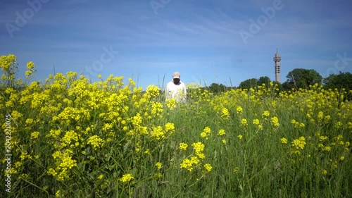 Stockholm, Sweden A man walks among wildflowers in summer on the Gardet field and the Kaknas Tower. 