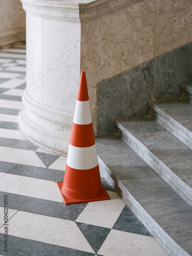 Traffic cone placed inside elegant architectural interior