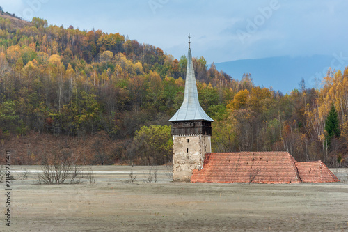 Church tower rising from the toxic tailings lake of Geamana, flooded by mining waste from Roșia Poieni copper mine, Apuseni Mountains, Romania. 