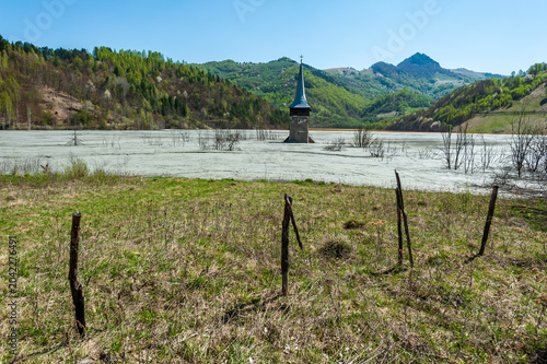 Church tower rising from the toxic tailings lake of Geamana, flooded by mining waste from Roșia Poieni copper mine, Apuseni Mountains, Romania. 