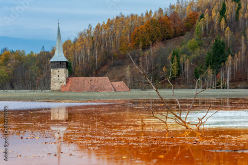Church tower rising from the toxic tailings lake of Geamana, flooded by mining waste from Roșia Poieni copper mine, Apuseni Mountains, Romania. 