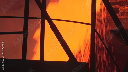 Фотография Intense Stream Of Molten Substance Overflows Protective Barrier Into Foggy Containment Zone