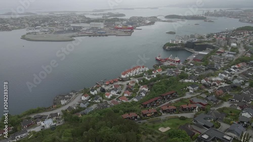 This high-quality aerial drone footage captures a quiet residential neighborhood on the outskirts of Stavanger, Norway. Filmed during the midday hours under a soft, overcast sky.