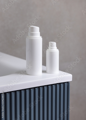White pump cosmetic bottles mockup on blue bathroom vanity. Skincare cosmetic packaging