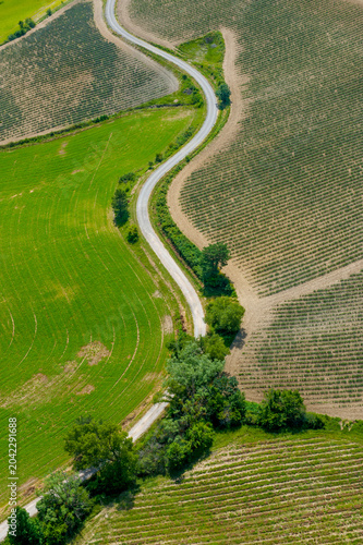 Photos Winding road dividing green and agricultural fields drôme-provençale france