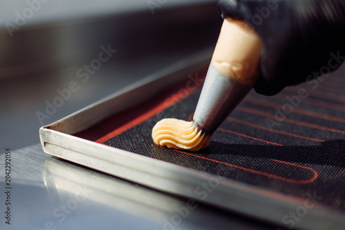 Fotografija use of a pouch to form baking eclairs, bakery concept