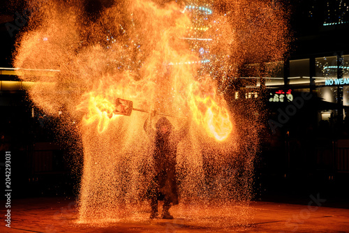 Fotografie Nighttime fire performance with flames and sparks in an urban plaza