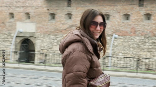 Young female tourist exploring historic European city square in spring