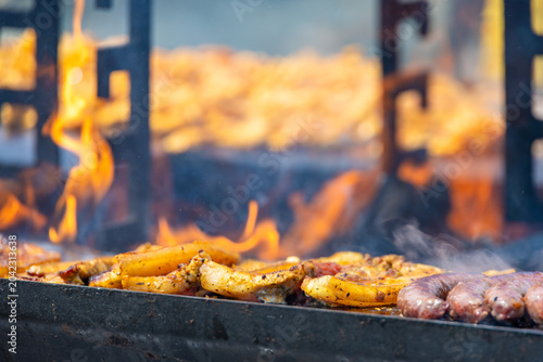 Foto A captivating, close-up commercial shot of seasoned pork belly steaks sizzling on a hot flat-top grill surface